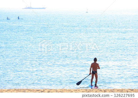 A young man rowing out into the open sea A young man rowing out into the open sea 126227695