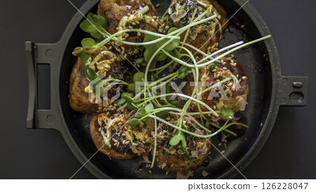 Takoyaki heated in a skillet 126228047