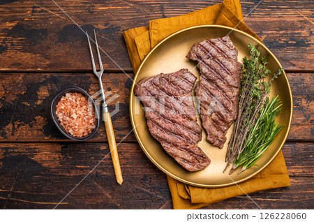 Juicy Denver, chuck eye steak, expertly grilled to perfection, offering a mouthwatering aroma and a deliciously charred exterior. wooden background. top view 126228060