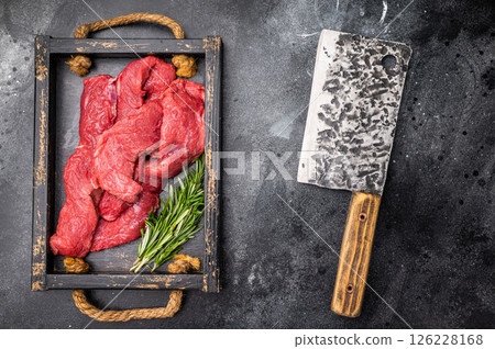 Vibrant raw bison meat pieces on a butcher block, illustrating the allure of this lean protein source for health-conscious culinary enthusiasts. black background. top view Vibrant raw bison meat pieces on a butcher block, illustrating the allure of this lean protein source for health-conscious culinary enthusiasts. black background. top view 126228168