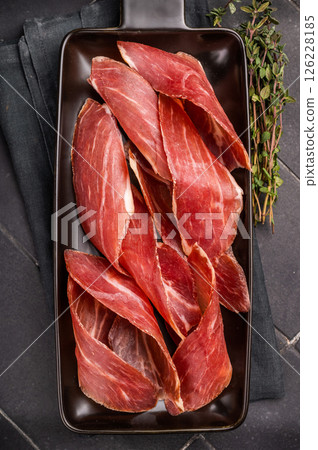 Dry cured and smoked serrano ham, pork meat. black background. top view 126228185