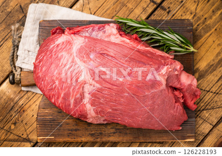 Fresh Raw Round Silverside beef meat cut, inside round with hrebs for roasting. wooden background. Top view Fresh Raw Round Silverside beef meat cut, inside round with hrebs for roasting. wooden background. Top view 126228193