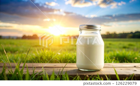 Milk in glass bottle on wooden table at sunset Milk in glass bottle on wooden table at sunset 126229079