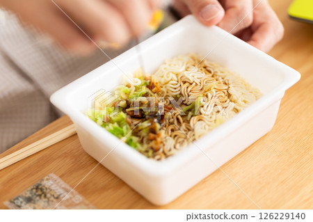Hands of a middle-aged man preparing cup noodles Hands of a middle-aged man preparing cup noodles 126229140