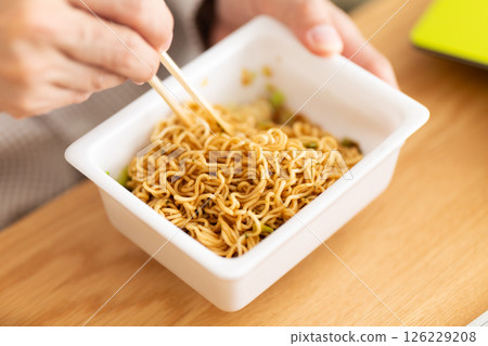 一位中年男子準備杯麵的手 一位中年男子準備杯麵的手 126229208