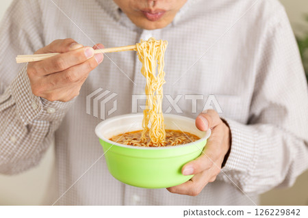 Middle-aged man eating cup ramen 126229842