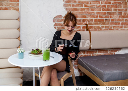 Creative woman using tablet while enjoying healthy cafe lunch 126230562
