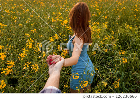 Romantic walk through blooming rapeseed field 126230660