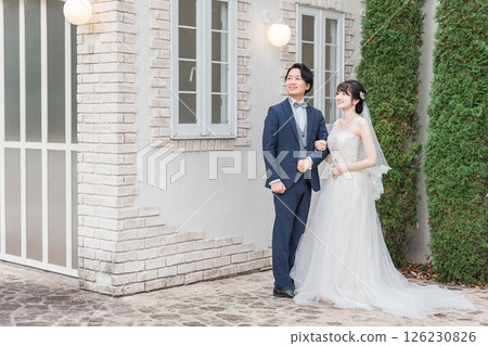 在婚禮儀式（花園婚禮）的婚禮大廳的花園裡交叉雙臂的新郎新娘 126230826