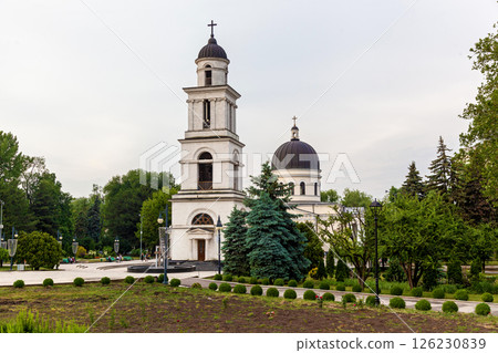 White church with bell tower and black domes surrounded by green park White church with bell tower and black domes surrounded by green park 126230839