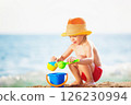 Happy child is playing with toys at sea shore background. 126230994