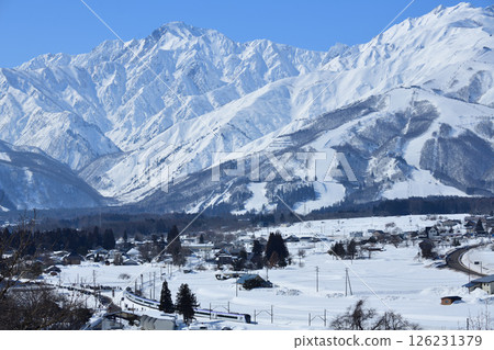 The E353 series express train runs along a curve on the Oito Line with the Northern Alps in the background. 126231379