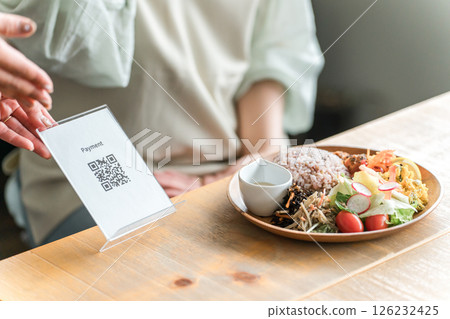 A staff member and a female customer presenting a QR code at a cafe 126232425