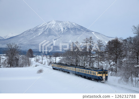 Snow-capped Mount Kurohime and Shinano Railway Skyline-colored 115 series train 126232788