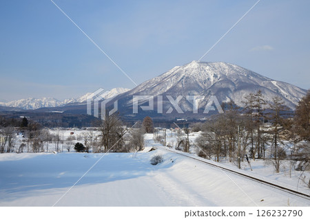 Snow-capped Mount Kurohime and the Shinano Railway tracks 126232790