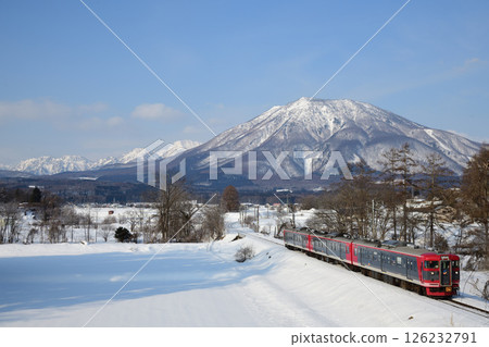 Snow-capped Mount Kurohime and Shinano Railway 115 series train 126232791