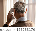 一位老人拿著聽筒打電話的後視圖 126233170