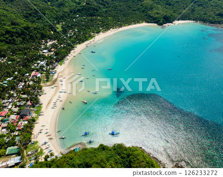 Fishing boats over turquoise water and white sands with sun reflection. Diapela Beach. El Nido, Philippines. 126233272