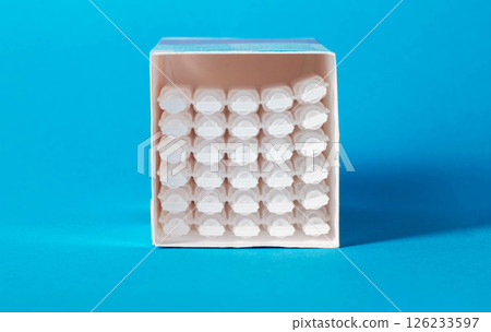 Tubes with medicine on a blue background. Concept of a laxative for the treatment of constipation in the intestines. Restoration of intestinal microflora, close-up 126233597