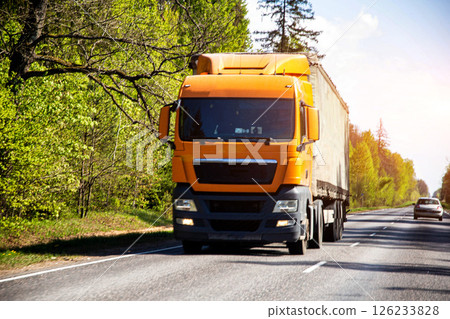 Modern orange truck tractor carries international cargo in a private company, business, industry 126233828