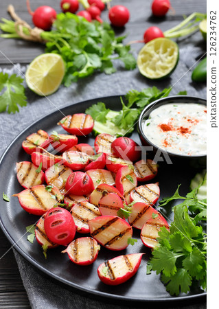grilled radishes with cucumber slices and sauce 126234762