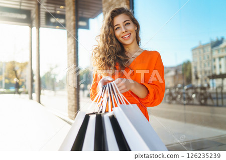 Young woman with shopping bags near mall. Purchases, shopping, lifestyle, sale concept. 126235239