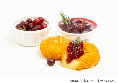 Camembert cheese fried in breading with cranberry sauce on white background 126235520
