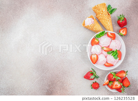 Beautiful Strawberry ice cream scoop in the bowl with waffle cones and berries, top view. copy space 126235528