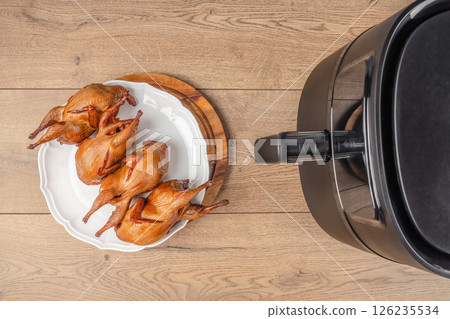 Baked quail air fryer oven on a wooden background. top view. copy space Baked quail air fryer oven on a wooden background. top view. copy space 126235534