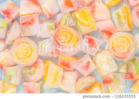 Blue background with ice cubes with frozen fruits 126235555