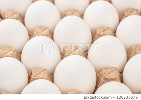 Natural organic chicken eggs in egg paper box. Close-up view. Hen farm eggshells collected arranged packaged for sale. 126235679