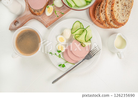 Sliced boiled ham sausage and boiled egg. Breakfast on a light background Sliced boiled ham sausage and boiled egg. Breakfast on a light background 126235690