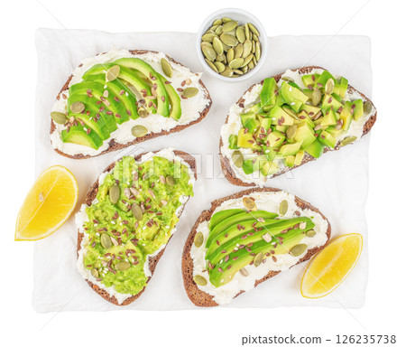 Healthy breakfast avocado toasts with cream cheese on plate isolated on white background. Top view. Vegan food concept 126235738
