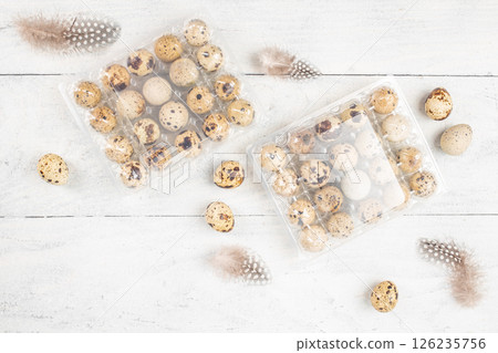 Containers of quail eggs packed by the farmer on a light background, ecological farm products. top view. copy space Containers of quail eggs packed by the farmer on a light background, ecological farm products. top view. copy space 126235756