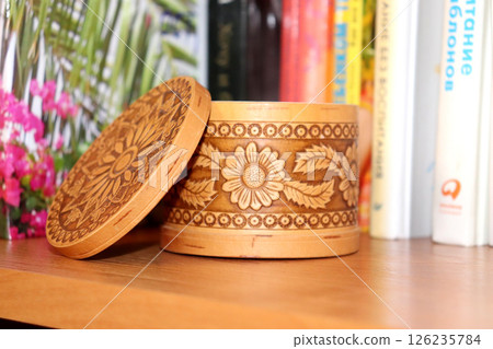 Handmade light brown round birch bark box with floral ornament carving with open lid 126235784