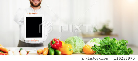 Digital Menu. Chef Man Showing Empty Tablet Computer Screen Cooking Food Standing In Restaurant Kitchen. Cropped, Mockup Digital Menu. Chef Man Showing Empty Tablet Computer Screen Cooking Food Standing In Restaurant Kitchen. Cropped, Mockup 126235979