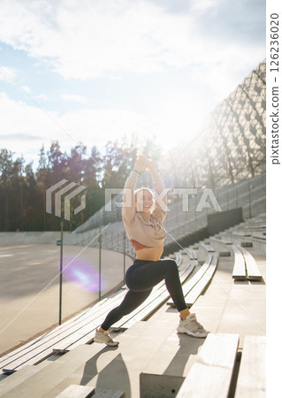 Beautiful woman outdoors and sportswear doing fitness. Concept of sport, recreation. 126236020