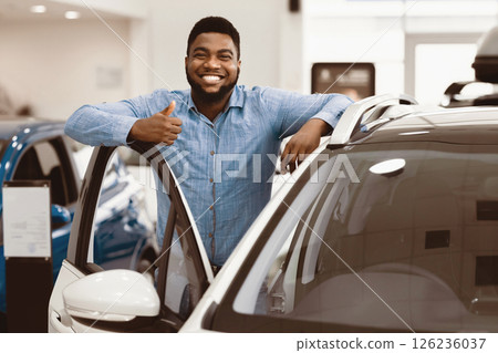 Great Car. Cheerful African American Guy Standing Near Auto Gesturing Thumbs Up Buying Vehicle In Dealership Center. Free Space Great Car. Cheerful African American Guy Standing Near Auto Gesturing Thumbs Up Buying Vehicle In Dealership Center. Free Space 126236037