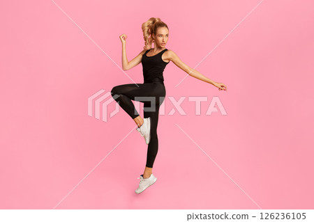 Fit Young Woman Exercising Jumping In Studio Over Yellow Background. Workout Concept. Vertical, Full Length 126236105