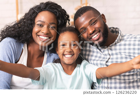 Selfie with parents. Cute little girl taking photo with her mom and dad, spending time together at home Selfie with parents. Cute little girl taking photo with her mom and dad, spending time together at home 126236220