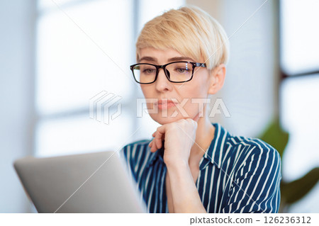 Middle-Aged Entrepreneur Lady Using Tablet Computer Reading Business News Online Sitting At Workplace Indoor. Selective Focus 126236312