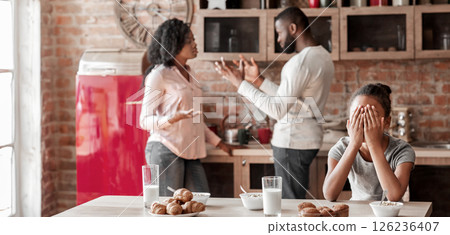 Family problems concept. African american little girl covering her eyes with hands, parents figting during breakfast, copy space 126236407