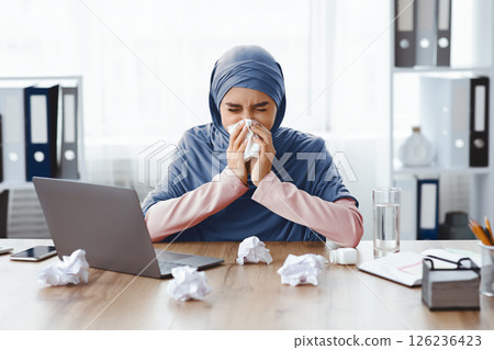 Sick employee suffering from virus but need to work, taking pills for flu and using laptop at home, copy space Sick employee suffering from virus but need to work, taking pills for flu and using laptop at home, copy space 126236423