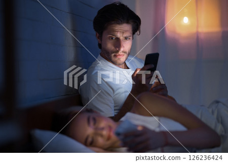 Cheating Concept. Shocked Man Catching Girlfriend Texting On Phone With Lover Lying In Bedroom At Night. Selective Focus, Low Light 126236424