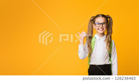 Back-To-School Sales. Joyful Schoolgirl Pointing Thumb At Empty Space For Text. Yellow Background, Panorama 126236483