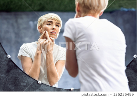 Mature Lady With Acne Problem Squeezing Pimple Standing In Bathroom At Home. Selective Focus, Free Space Mature Lady With Acne Problem Squeezing Pimple Standing In Bathroom At Home. Selective Focus, Free Space 126236499
