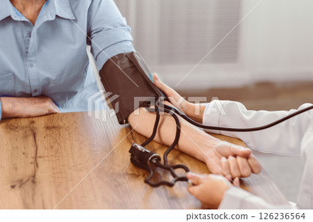 Community Outreach. Unrecognizable nurse measuring blood pressure of elderly man at home, copyspace, close up, copyspace Community Outreach. Unrecognizable nurse measuring blood pressure of elderly man at home, copyspace, close up, copyspace 126236564