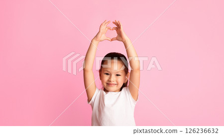 Adorable little asian girl showing heart gesture with fingers and hands up over pastel pink studio wall, copy space Adorable little asian girl showing heart gesture with fingers and hands up over pastel pink studio wall, copy space 126236632
