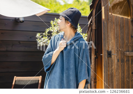 A man taking an outdoor bath after a sauna 126236681