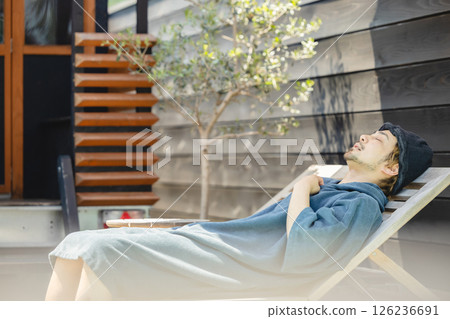 A man taking an outdoor bath after a sauna session 126236691
